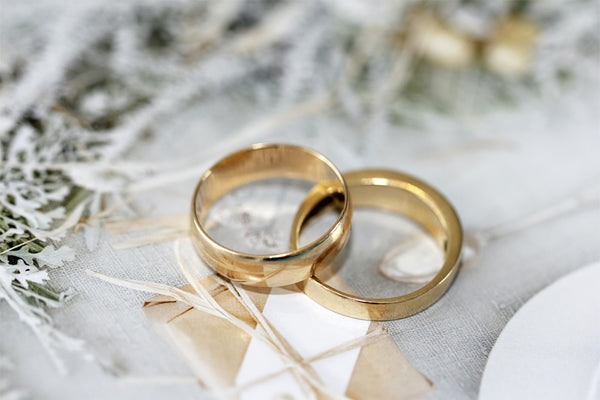 gold wedding bands on white fabric