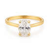 Gold plated engagement ring with an oval diamond on a white background