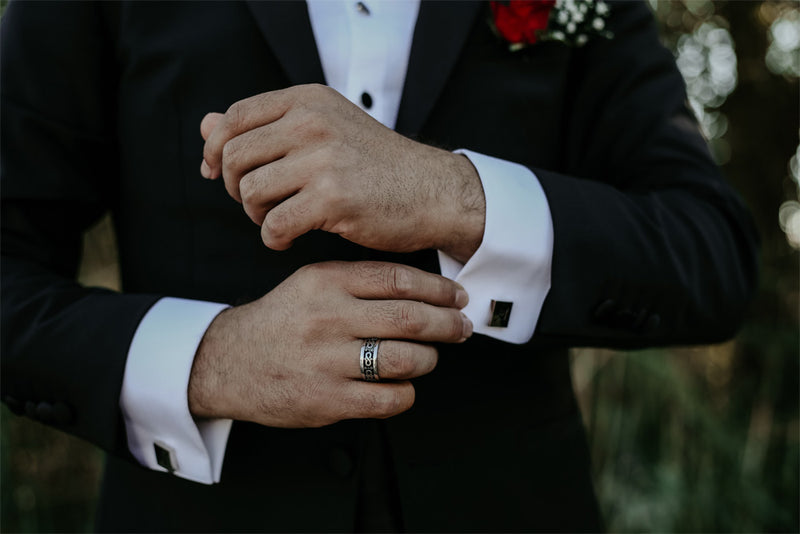 man in suit wearing a silver type of men’s wedding band