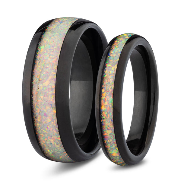 Two black tungsten his and hers rings with white opal inlay on a white background
