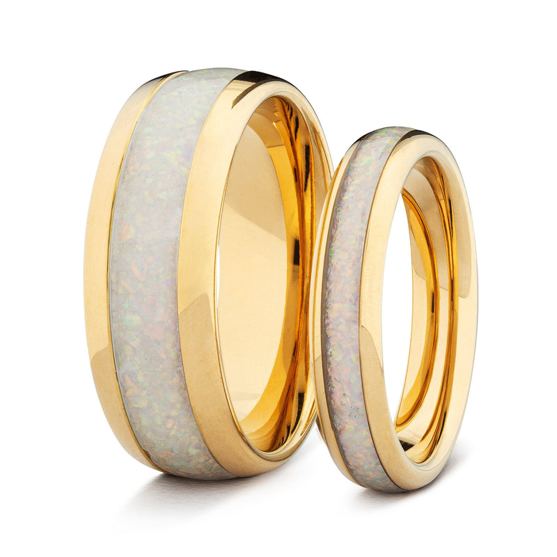 Two gold his and hers wedding bands with white opal on a white background