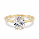 Gold solitaire ring with a large oval diamond on a white background