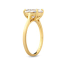 Standing gold engagement ring with an oval diamond on a white background