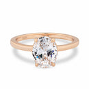 Rose gold solitaire ring with a large oval diamond on a white background