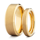 Two gold his and hers wedding bands on a white background