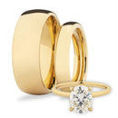 Two his and hers gold wedding bands with an oval diamond solitaire on a white background