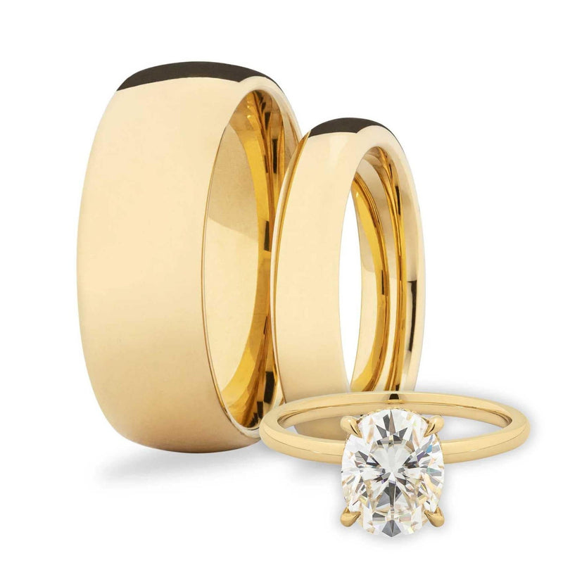 Two his and hers gold wedding bands with an oval diamond solitaire on a white background