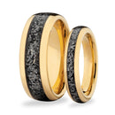 Two gold wedding bands with meteorite on a white background