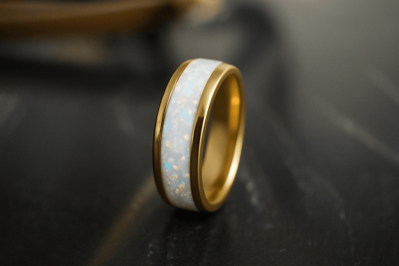 a white opal wedding ring with a gold band standing upright