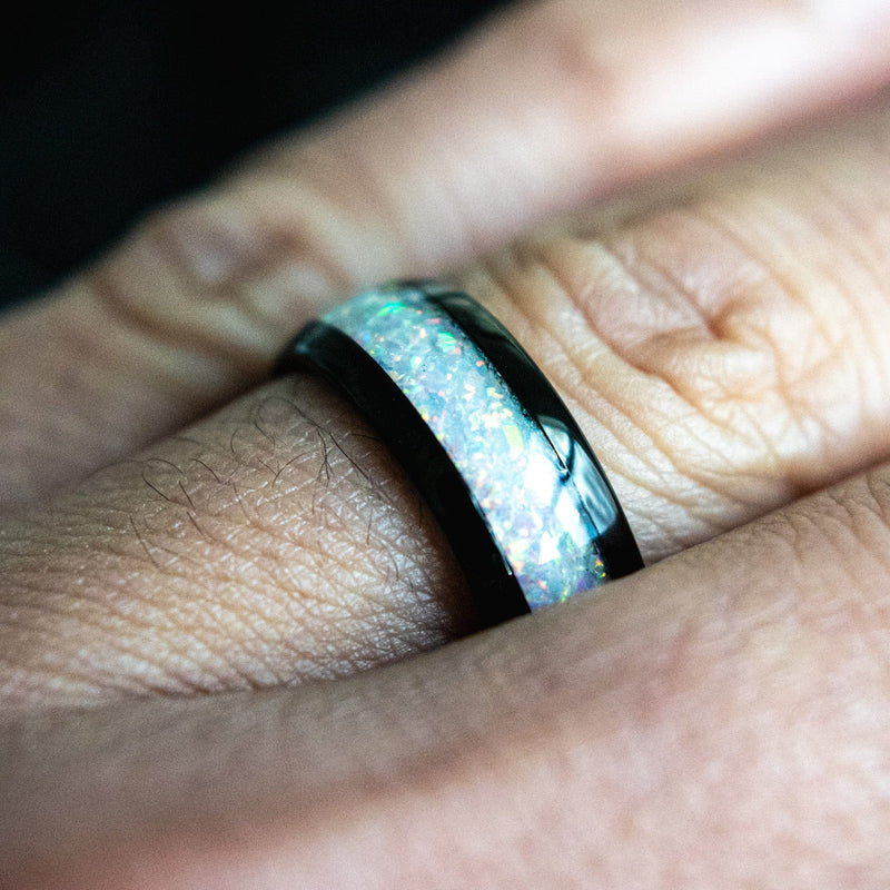 opal ring with black trim on a hand