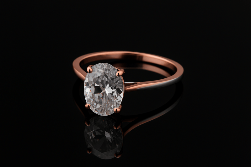 rose gold oval diamond ring in front of a black background