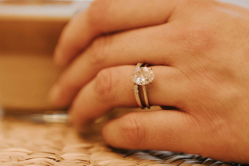 Woman’s hand wearing a stack with a sterling silver eternity band 
