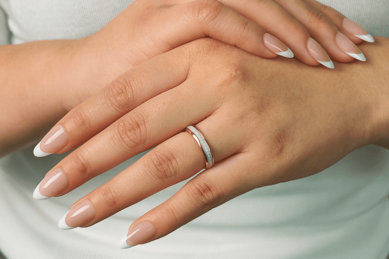 a yellow gold opal ring on a woman’s hand